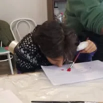 Una participante dibuja sobre una hoja durante el taller de arte.