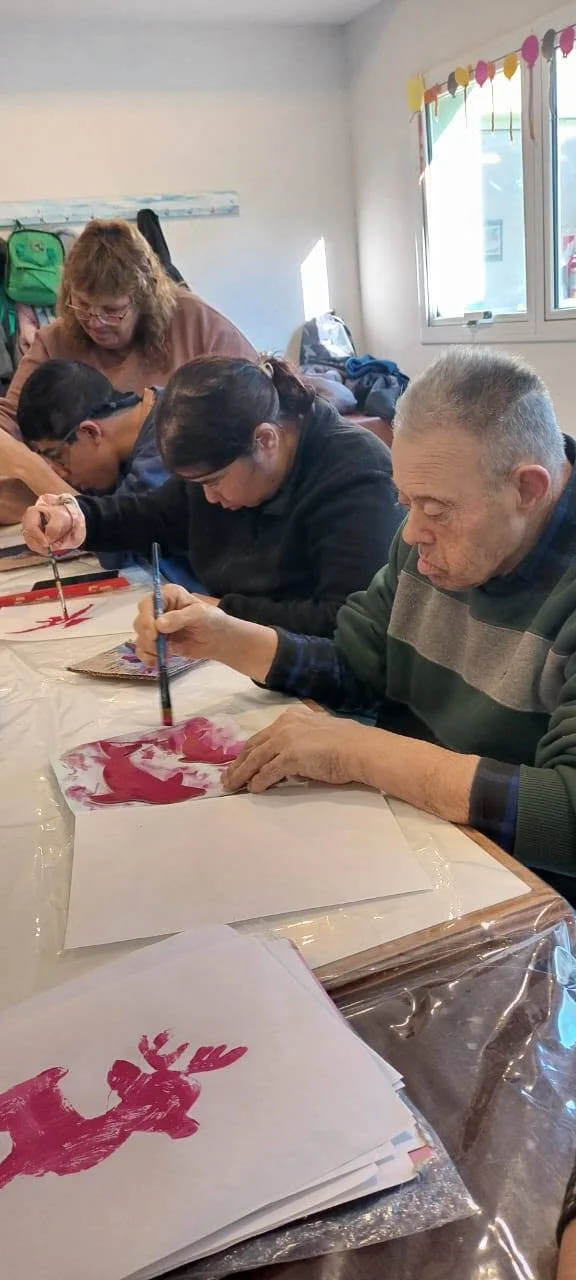 Participantes pintan en una mesa compartida.