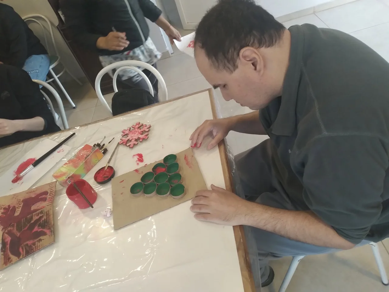 Un participante trabaja con pinturas de colores en el taller de arte.