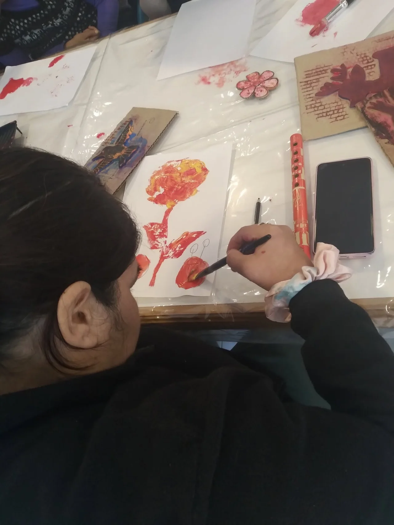 Un participante pinta figuras rojas sobre una lámina.