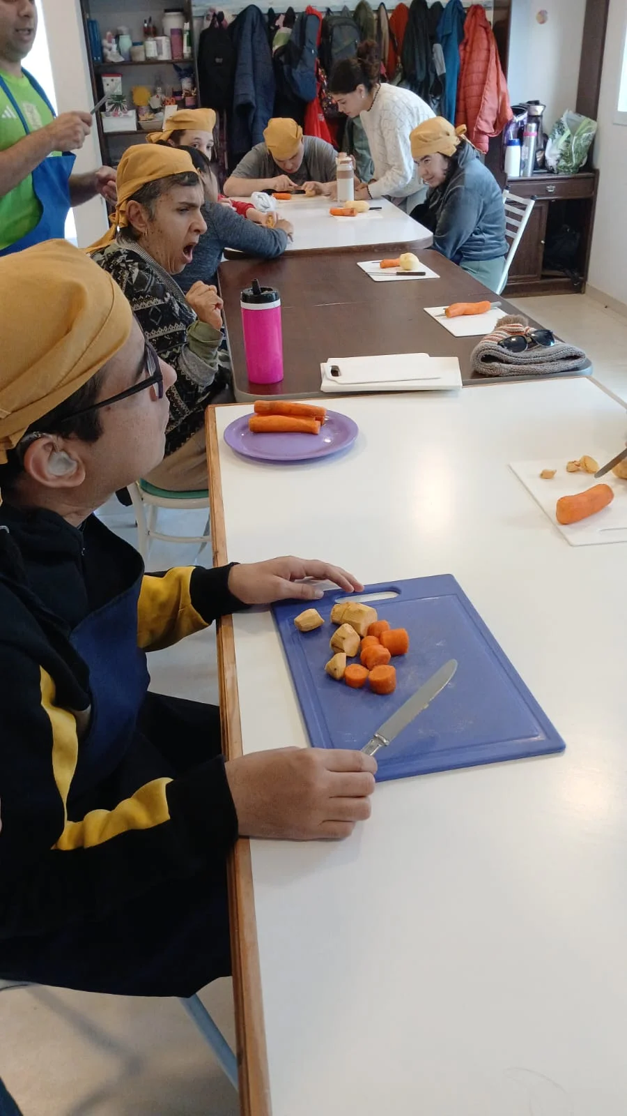 El grupo prepara alimentos alrededor de una mesa.