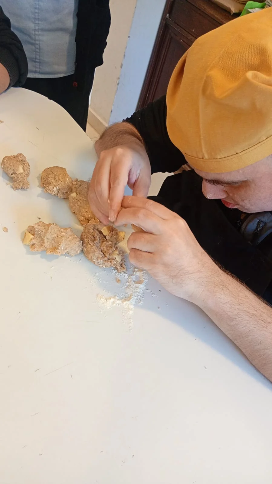 Un participante da forma a la masa con las manos.
