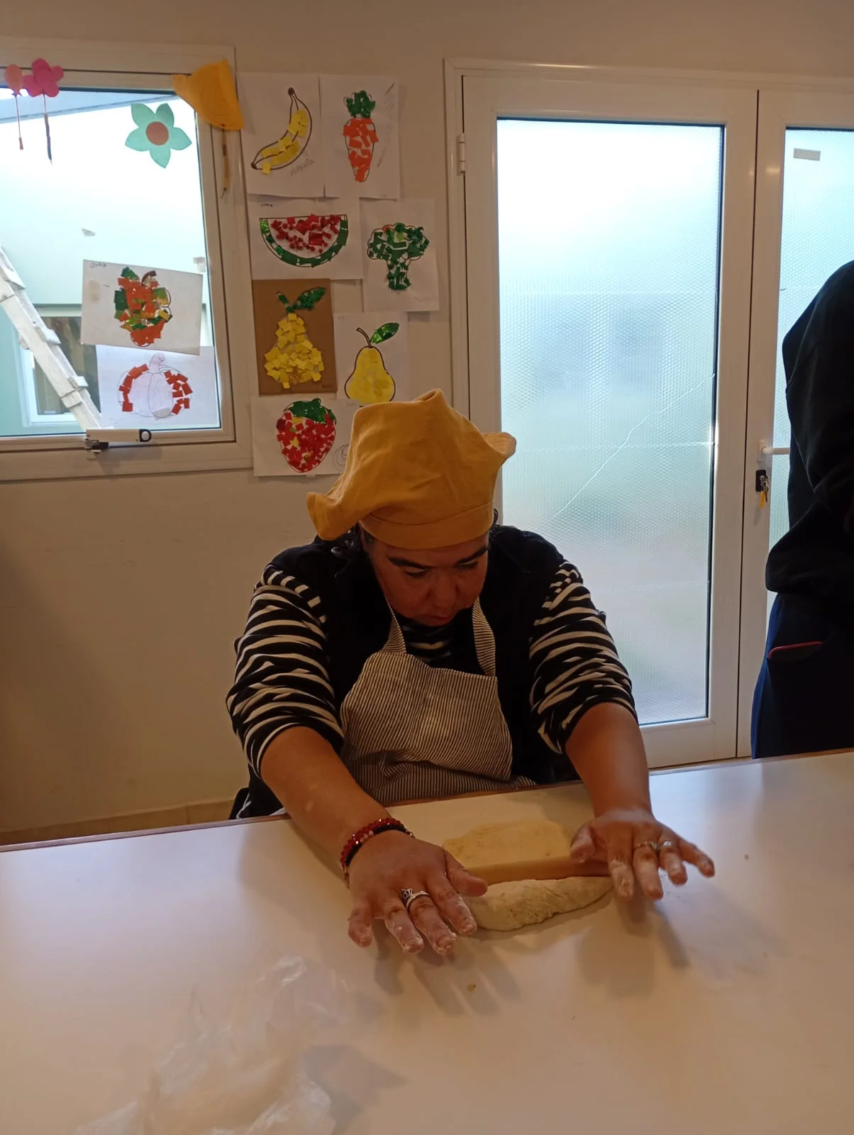 Un participante amasa sobre una mesa en el taller de cocina.