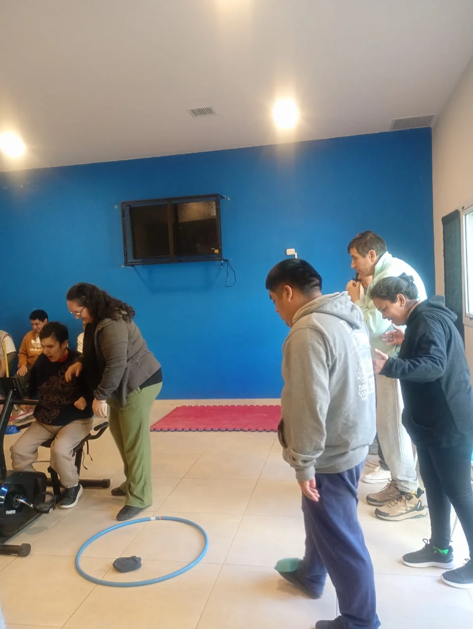Un grupo realiza una actividad con aros en el suelo.