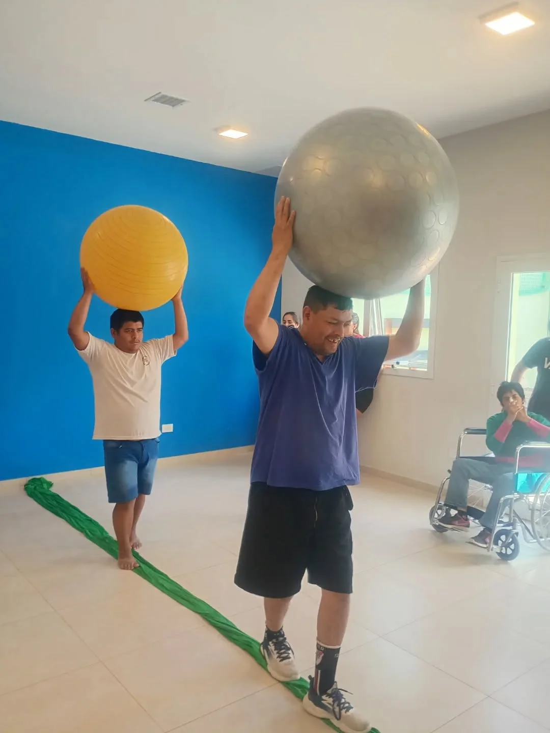 Dos participantes levantan pelotas durante una actividad grupal.