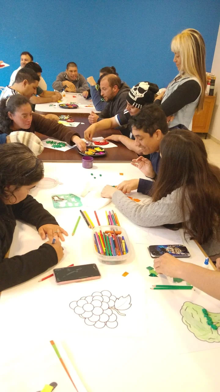 Un grupo comparte una actividad de psicomotricidad alrededor de una mesa.