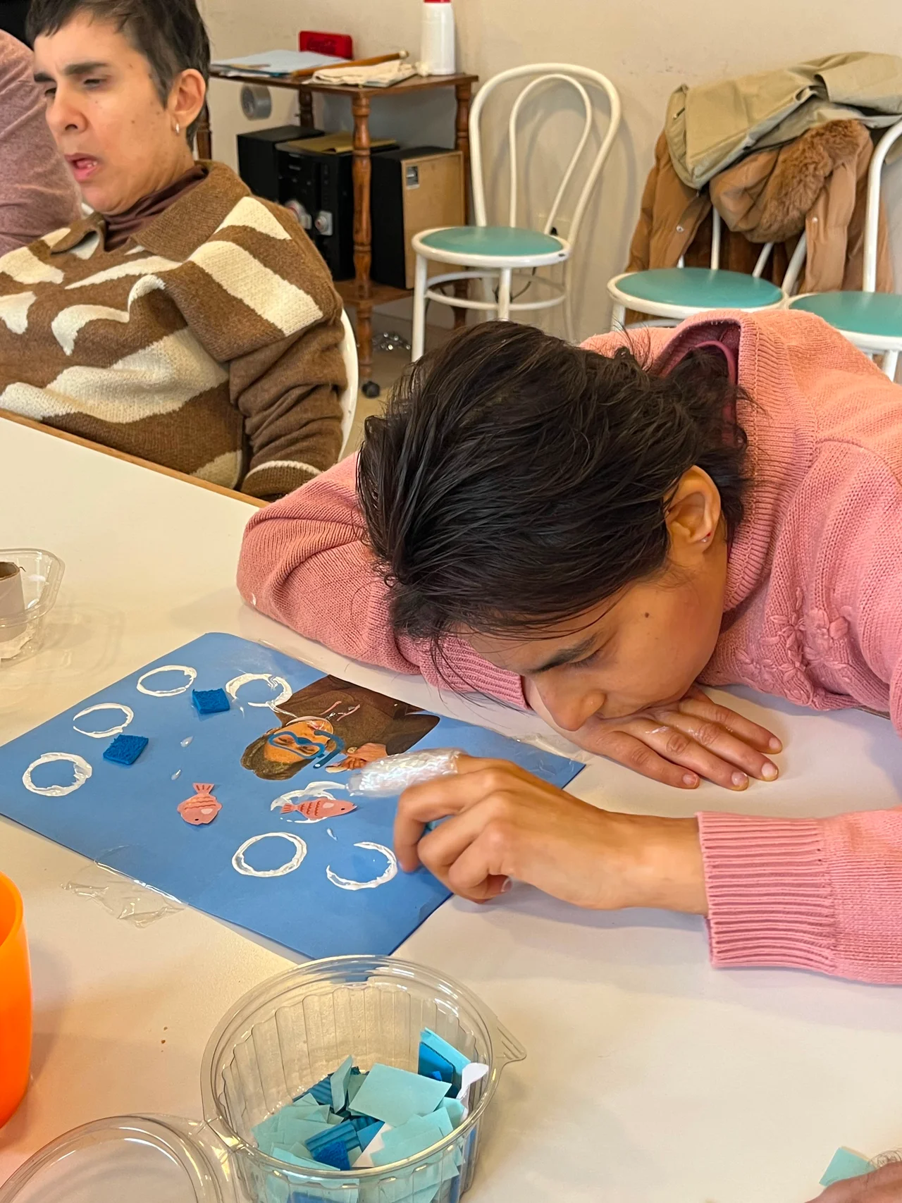 Una participante se acerca a los materiales dispuestos sobre una mesa.