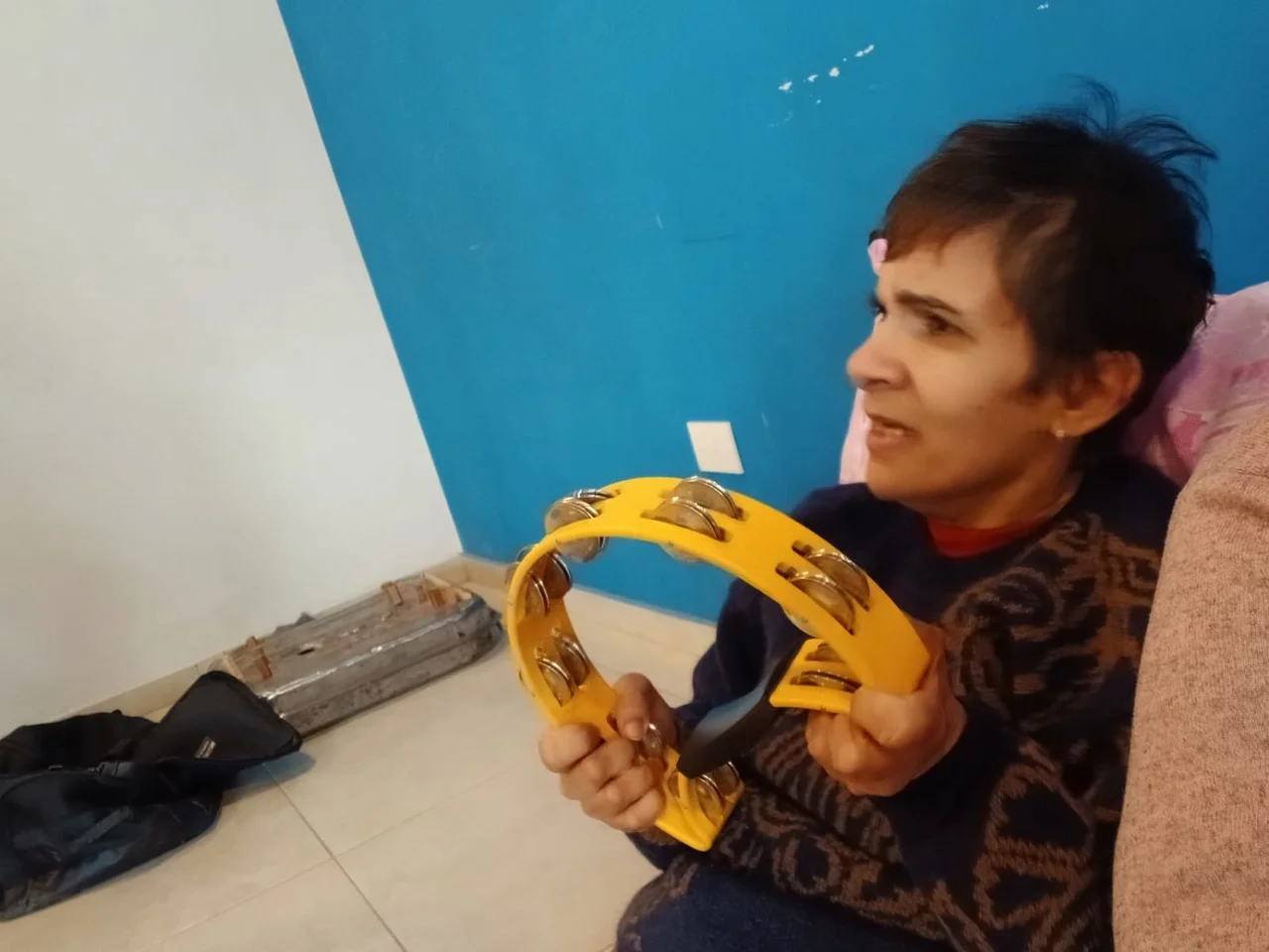 Una participante sostiene una pandereta amarilla.
