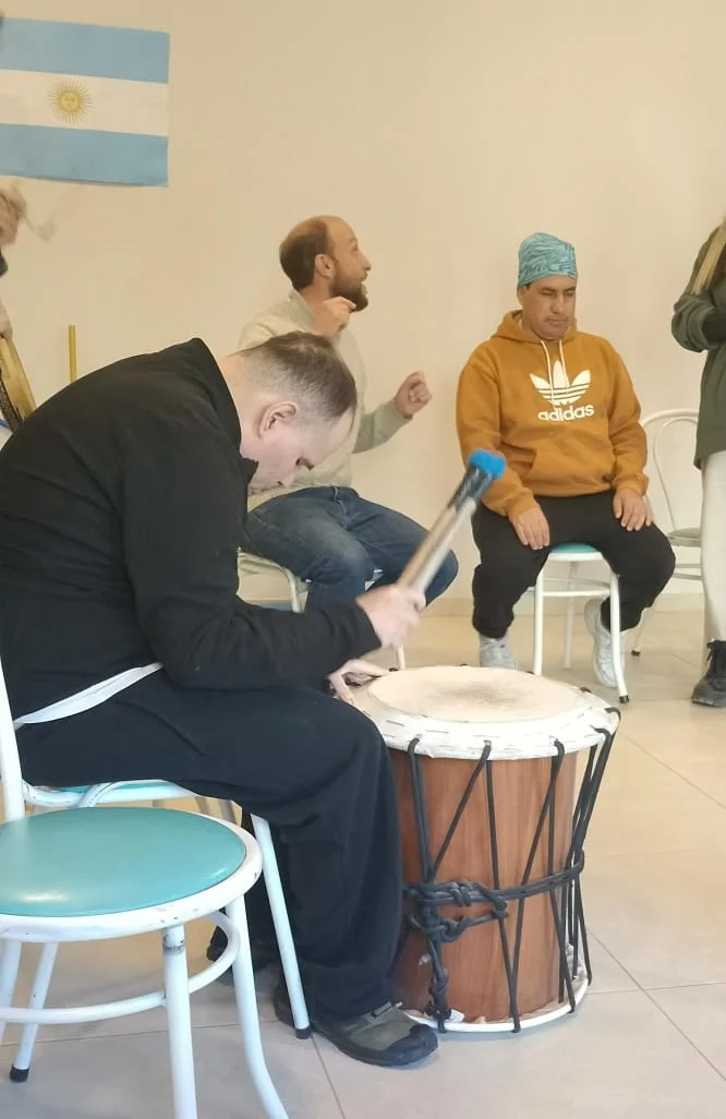Personas reunidas alrededor de un tambor en el taller.