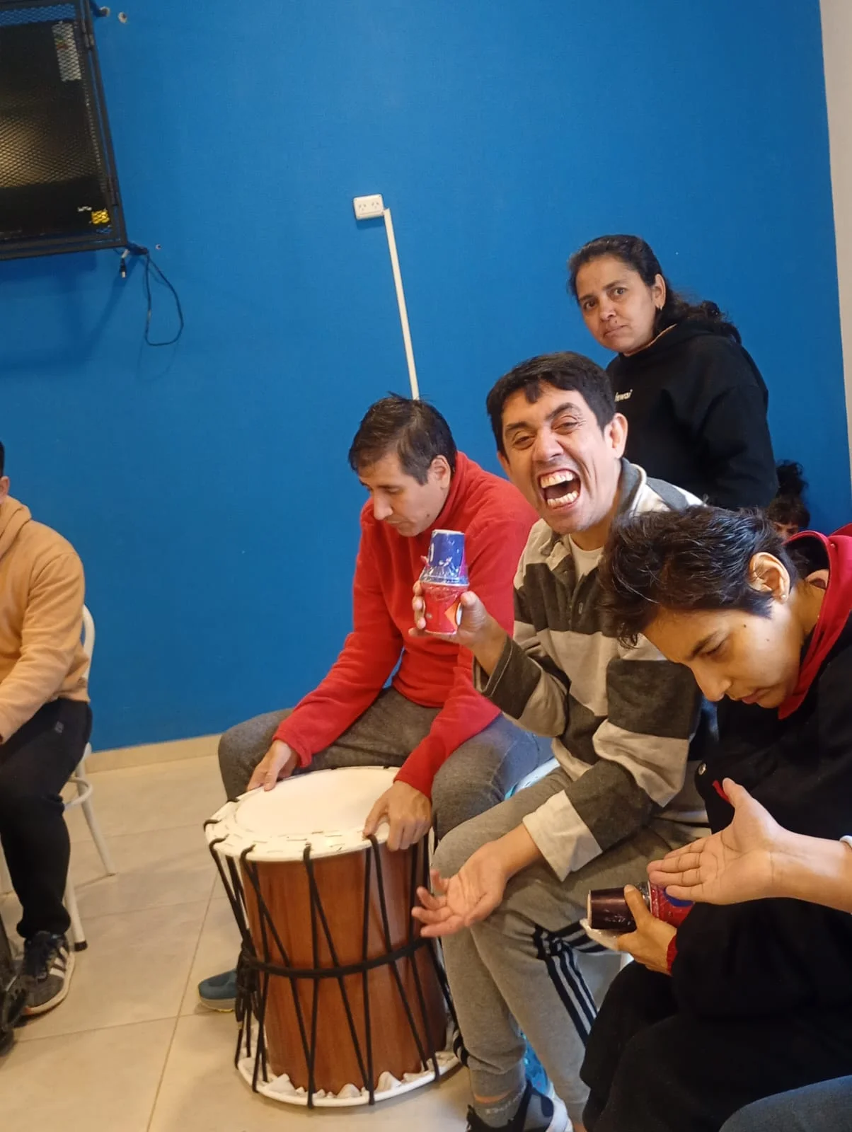 Participantes tocan tambores en grupo.